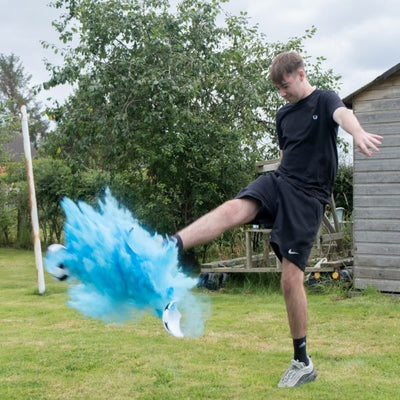 young man kicked an exploding blue powder football
