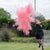 young man hitting an exploding pink powder cricket ball