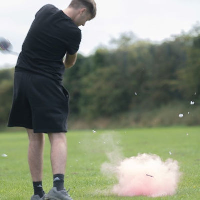back view of male and an exploding pink golf ball